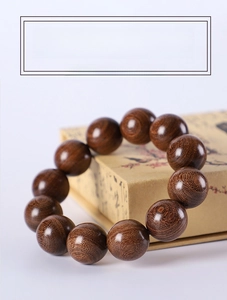 Macro detail of polished green sandalwood beads with visible natural wood grain texture
