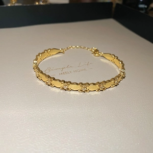 Detail of 18k gold plated iris motif bracelet with cubic zirconia and lobster clasp