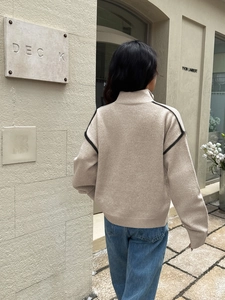 Beige zip-up knit sweater with black stripes on sleeves and casual high collar design