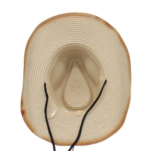 Detail view of woven straw hat interior with sweatband and black adjustable wind rope
