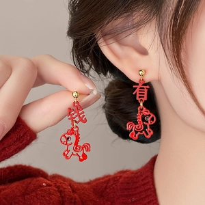 Macro detail of red enamel earrings with Lucky Chinese characters and horse pendant