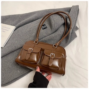 Detail of dark brown vintage pillow bag with glossy finish and two front pockets