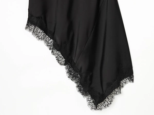 Detail of elegant black satin hem with exquisite eyelash lace trim on the dress