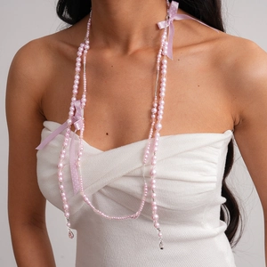 Détail d'un collier de perles roses avec nœud en soie et pampilles gouttes d'eau