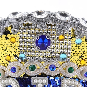 Close-up of sparkling blue sequins and gemstone embellishments on a festive crown hat