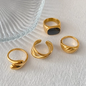 Detailweergave van vier minimalistische vergulde ringen in diverse geometrische ontwerpen