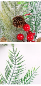 Detailed close-up of artificial pine needles with red berries, pine cones and snow frost