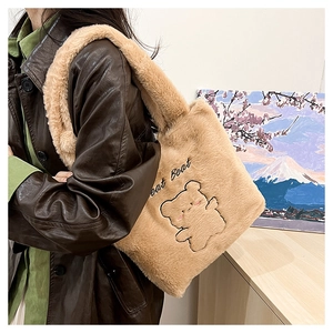 Détail du sac cabas en peluche montrant la fausse fourrure douce et l'ours brodé avec texte