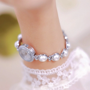 Close-up of elegant pearl bracelet watch with silver metal links on a model's wrist