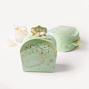Elegante scatola regalo a corona verde chiaro con motivi dorati e fiocco in nastro