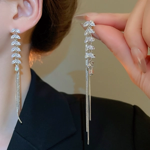 Detail showing elegant long silver tassel earrings with leaf-shaped zircon crystals
