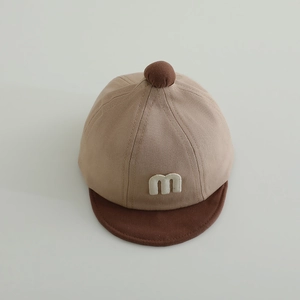 Detail der Baby-Baseballkappe mit weißem M-Stick und weichem khakifarbenem Baumwollstoff
