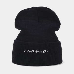 Close-up of black knitted beanie featuring white mama embroidery and ribbed texture