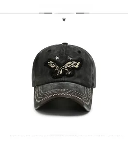 Detail of embroidered eagle and stars on vintage washed dark grey denim baseball cap