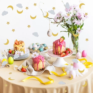 Gold star, moon and grey cloud confetti set on a festive Easter table background