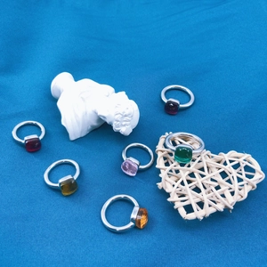 Silver stainless steel rings with square colorful zircon stones on a blue fabric