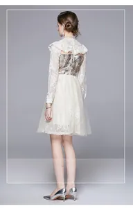 Detail of colorful floral embroidery and delicate lace on the back of a vintage dress