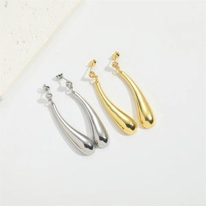 Detailed view of polished teardrop earrings in gold and silver with cubic zirconia