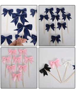 Close-up of satin bow cake toppers in navy, pink, and white for party decor
