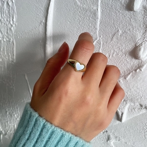 Detail of 925 silver heart ring with white shell inlay worn on model's finger