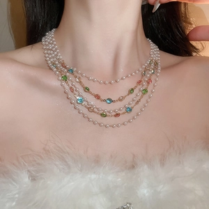 Détail d'un collier de perles multicouche avec pierres précieuses sur le mannequin