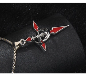 Close-up of a silver stainless steel cross pendant with red drip oil detail on box chain