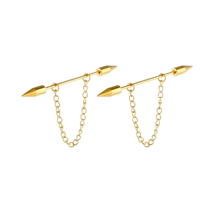 Detail of golden arrow earrings with pointed studs and hanging delicate chain links