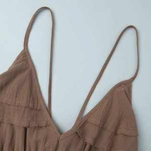 Détail du décolleté en V avec volants superposés et bords francs sur robe en coton marron