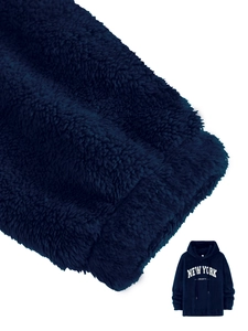 Detail of navy blue fleece hoodie texture with New York printing and cozy plush fabric