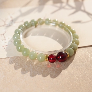 Close-up of Hetian jade beads and red agate accents on a vintage beaded bracelet