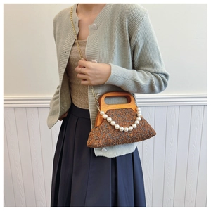Detail of vintage wool woven handbag with pearl chain and elegant wooden handle