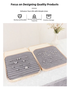 Detail view of champagne gold jewelry trays with grey velvet inserts for rings and studs