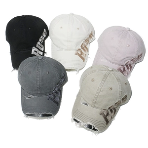 Detail of distressed baseball caps with ROSE embroidery and vintage frayed texture