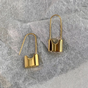 Detailed close-up of gold-plated lock-shaped earrings with a polished mirror finish