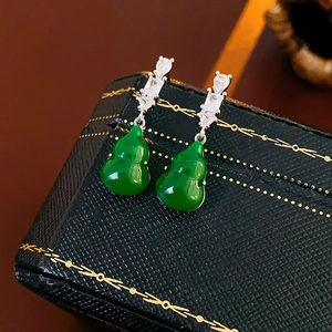 Macro shot of dark green gourd earrings with cubic zirconia and silver needles detail