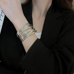 Detail of multi-layer silver winding cuff bracelet with a minimalist metallic finish