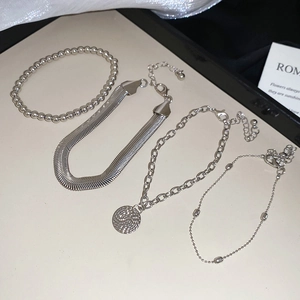 Détail de l'ensemble de quatre bracelets en métal argenté avec divers styles de chaîne