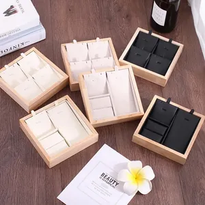 Wooden jewelry display tray set for rings and necklaces on dark wood background