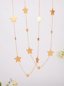 Macro view of tiered gold stainless steel necklaces with dangling star charms