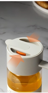 Close-up of glass oil dispenser with automatic lid and 500ml capacity scale markers