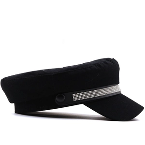 Detail of sparkling rhinestones on black military style flat top cap with leather strap
