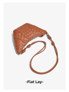 Detailed top view of brown woven leather croissant bag with knotted strap detail