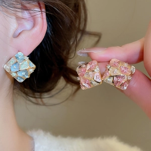 Detailed macro view of square enamel earrings with blue and pink accents and micro-set zircons