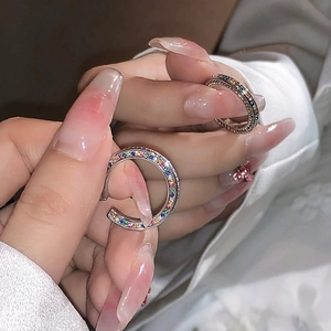 S925 sterling silver hoop earrings with colorful cubic zirconia in hand-held macro view