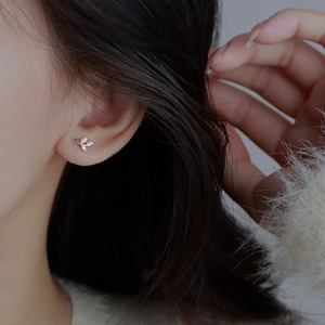 S999 sterling silver leaf stud earrings with sparkling diamonds on a model