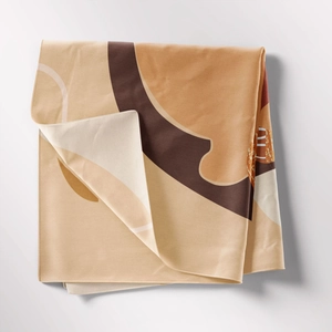 Detailed close-up of folded bohemian tapestry with abstract earth-toned geometric patterns