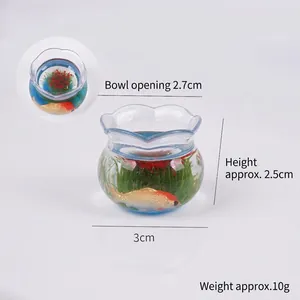 Miniature fish tank ornament with red koi goldfish and green plants inside resin bowl