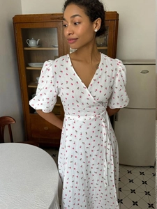 Detailed view of white floral cotton dress with puff sleeves and waist tie design