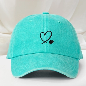 Close-up of heart embroidery detail on mint green washed cotton baseball cap texture