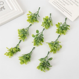 Detailed view of nine artificial green boxwood shrub sprigs for DIY Christmas decoration
